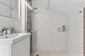 Ein Badezimmer mit Dusche, Waschbecken und Toilette.