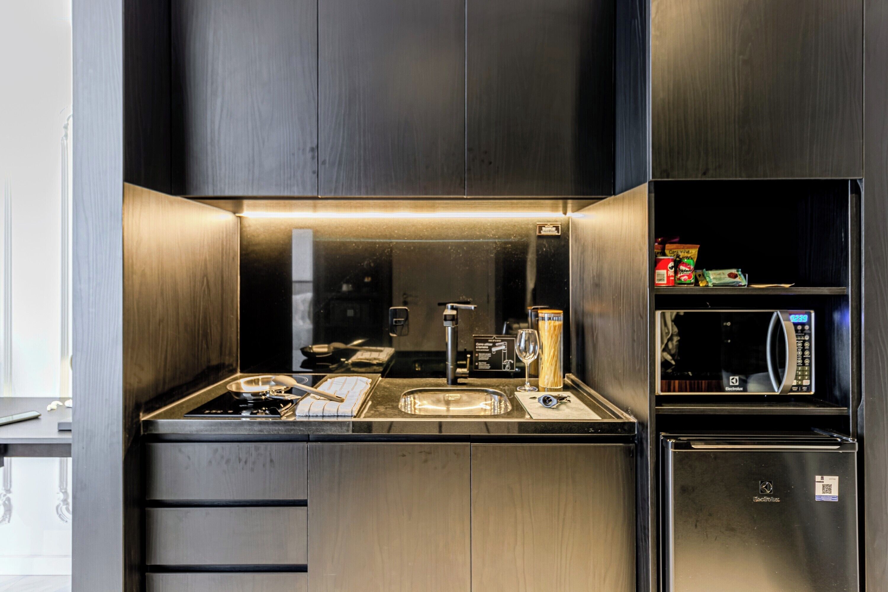 Een moderne keuken met roestvrijstalen apparatuur, een inbouwmagnetron en een oven met glazen deur.