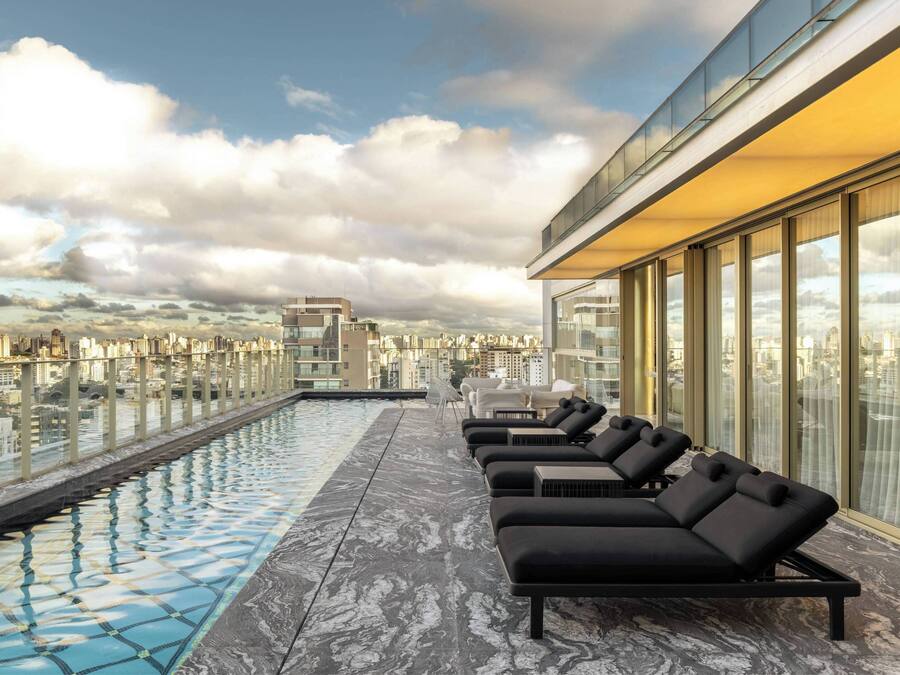 Una piscina al aire libre, sillones reclinables de piscina