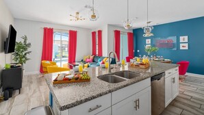 A modern kitchen with granite countertops, stainless steel appliances, and a breakfast bar. - Gatsby Gamehouse (Kissimmee)