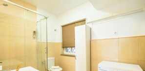 Ein Badezimmer mit Duschkabine aus Glas, Toilette und Waschbecken.