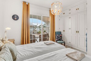 Una camera da letto con un letto, una sedia, un armadio e vista su un patio esterno.