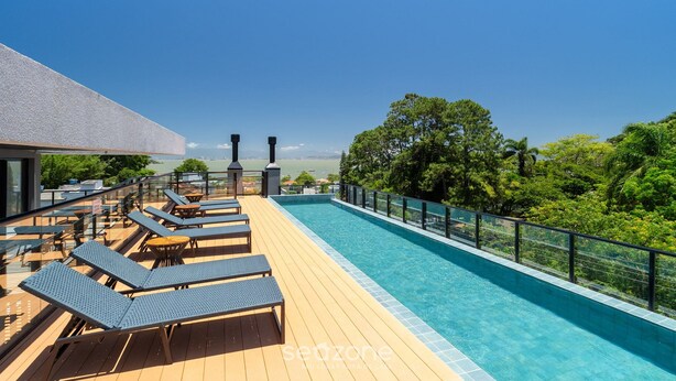 A rooftop pool area with lounge chairs and a view of the landscape. - Estúdio premium com varanda e sol da manhã SGR0217 (Florianópolis)