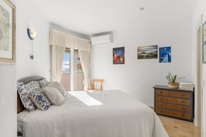 A bedroom with a bed, a chair, a dresser, and wall art. - Spectacular Sea Views, Pool & Garden – Calahonda Apartment for 6 (Sitio de Calahonda)