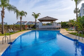 A swimming pool with lounge chairs, a gazebo, and palm trees. - Private Jacuzzi for Romantic Getaways a221 (Mijas Costa)