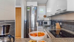 A modern kitchen with a stainless steel refrigerator, a microwave, and a coffee maker.