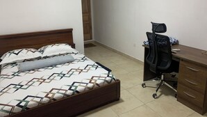 Ένα υπνοδωμάτιο με ένα κρεβάτι, ένα γραφείο και ένα κλιματιστικό.