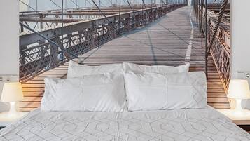 A bed with a geometric patterned bedspread, two white pillows, and two bedside lamps.
