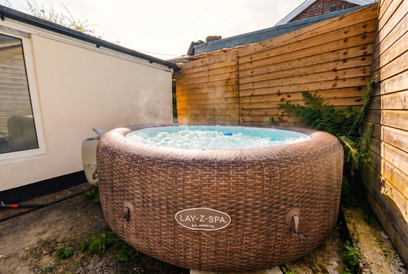 En bubbelpool av märket ”Lay-Z-Spa” placerad i en trädgård.