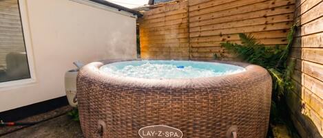 En bubbelpool av märket ”Lay-Z-Spa” placerad i en trädgård.