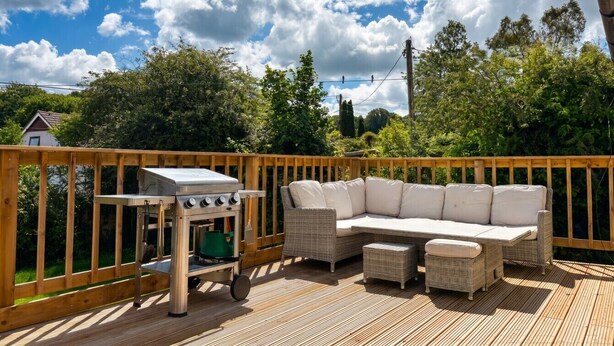 A deck with outdoor furniture, a grill, and a view of the surrounding greenery. - Family-friendly countryside home with hot tub, swing set and trampoline (Battle)