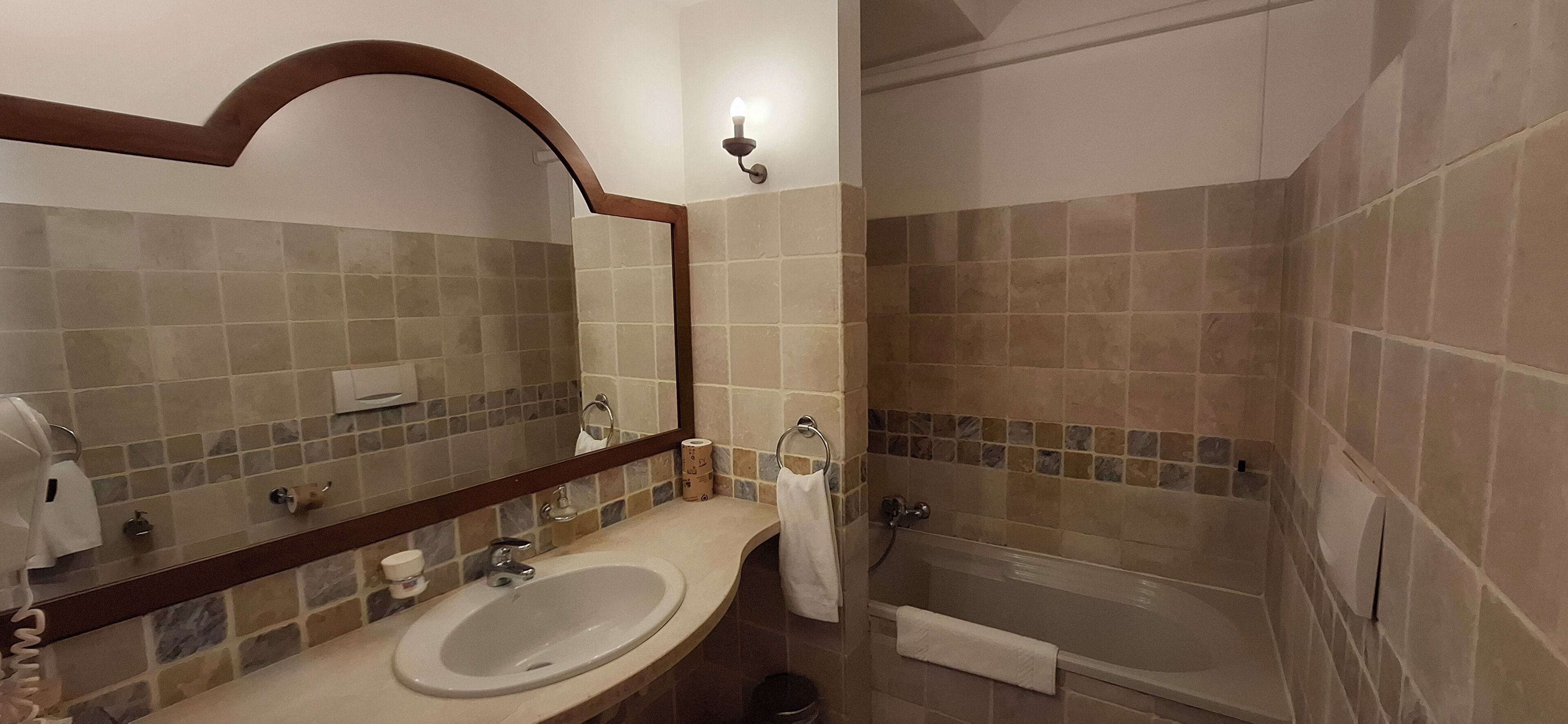 Ein Badezimmer mit Waschbecken, Spiegel und Badewanne.