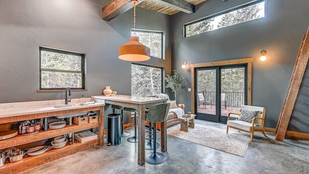 A modern kitchen with a bar area, large windows, and a view of the outdoors. - Secluded Modern Cabin- Near Flathead Lake (Polson)