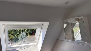 Una habitación con tragaluz, ventana grande y espejo.