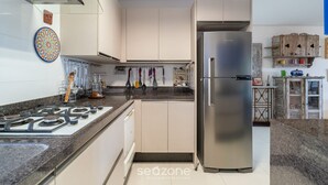 Une cuisine moderne équipée d’un réfrigérateur en acier inoxydable, d’une cuisinière à gaz et d’un lave-vaisselle.