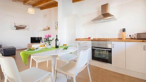 A modern kitchen with white cabinets, a stainless steel oven, and a wooden countertop.