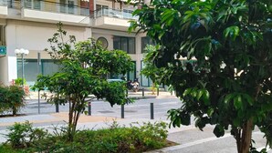 A multi-story residential building with balconies, a paved courtyard, and greenery. - Apartment 'Phidias House' with Balcony, Wi-Fi and Air Conditioning (Thessaloniki)