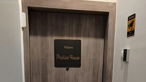 A wooden door with a sign reading 'Welcome Phidias House.' - Apartment 'Phidias House' with Balcony, Wi-Fi and Air Conditioning (Thessaloniki)
