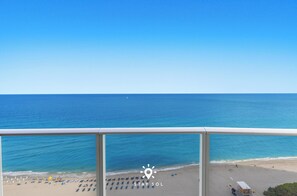 A beach view from a balcony with a clear sky, a sandy beach, and a lifeguard tower. - Oceanline 3BR  Corner Balcony & Calm Seas (Hollywood)