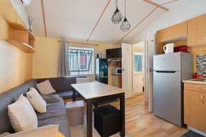 Eine moderne Küche mit Kühlschrank, Holzschränken und einem Esstisch.