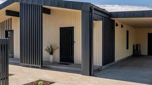 A modern building with a flat roof, large windows, and a minimalist design. - Nordic Zen 2BR Beach House • Bali-Inspired Calm (Vārzas)