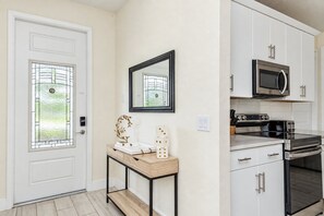 A modern kitchen with white cabinetry, a stainless steel oven, and a microwave. - Reunion 3BR Villa Near Disney + Pool Access (Kissimmee)
