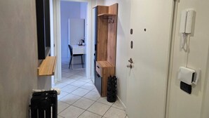 A narrow hallway with a white door, a wooden cabinet, and a tiled floor. - RHO FIERA FLAT- 100 M FROM THE METRO (Pero)