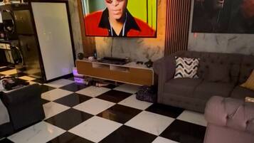A living room with a checkered floor, a television, a sofa, and a coffee table.