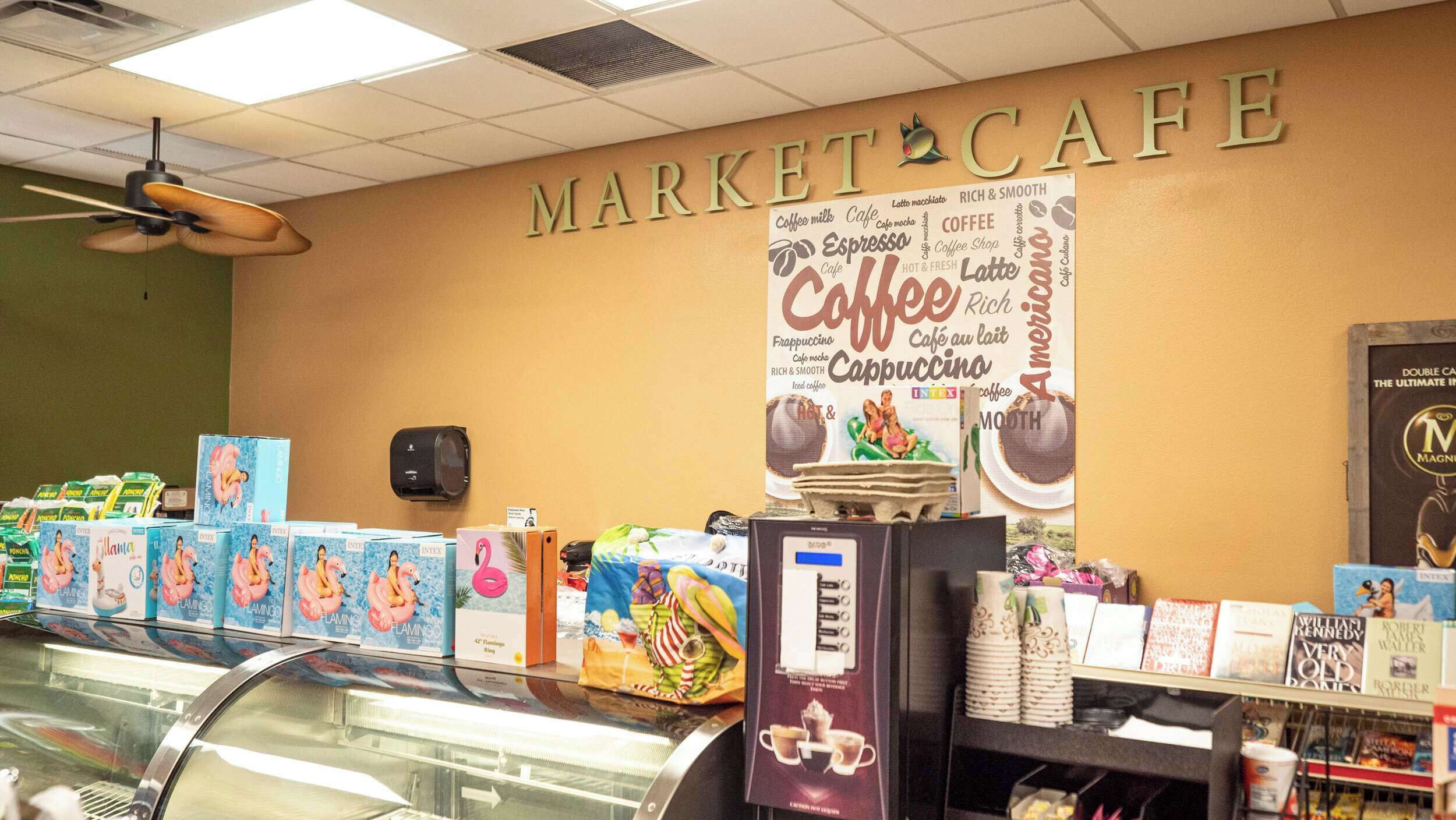 A market cafe with a coffee-themed wall sign and various coffee products on display.