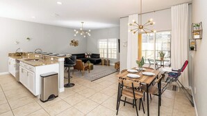 Una cocina moderna con comedor, sofá y vistas al exterior.