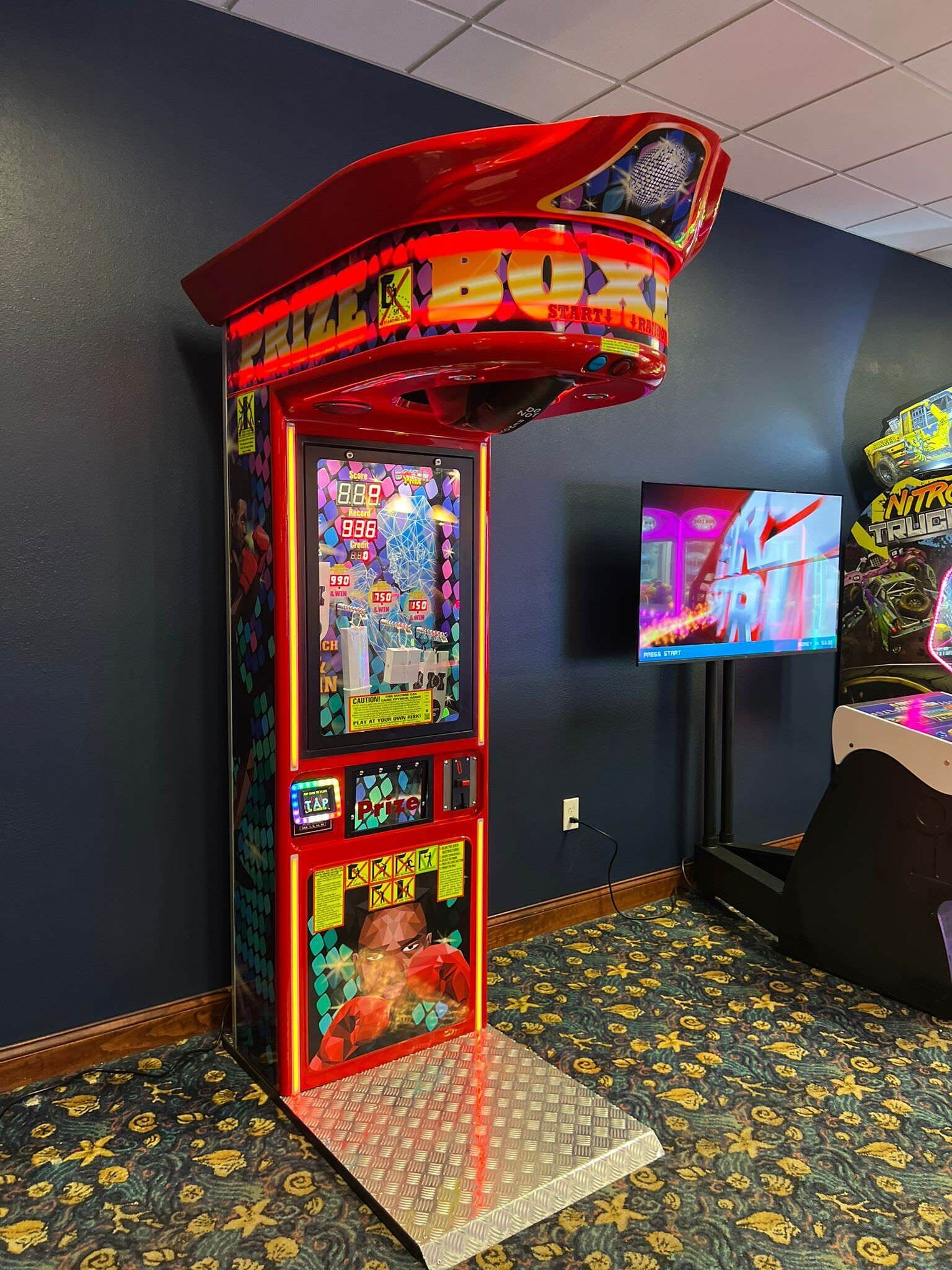 Une borne d’arcade avec un jeu de griffe, dotée d’un écran numérique et d’un espace pour les prix.