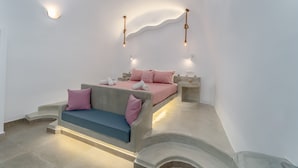 Un dormitorio moderno con cama, mesitas de noche y un sofá.