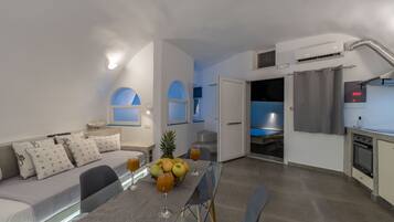 A modern living space with a dining area, kitchenette, and a bedroom with a balcony.