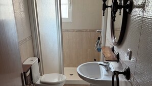 A bathroom with a toilet, bidet, and sink.