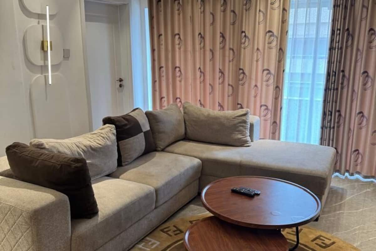 Una sala de estar moderna con un sofá modular, una mesa de centro redonda y una alfombra estampada.