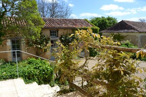 A rustic stone building with a tiled roof, surrounded by lush greenery and a wooden fence. - FORGET STRESS, THE PERIGORD COUNTRYSIDE IS GENTLE (Nouvelle-Aquitaine)