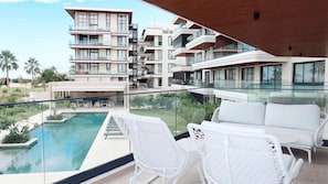 Ein modernes Hotel mit Pool, Sitzgelegenheiten im Freien und Blick auf andere Gebäude.