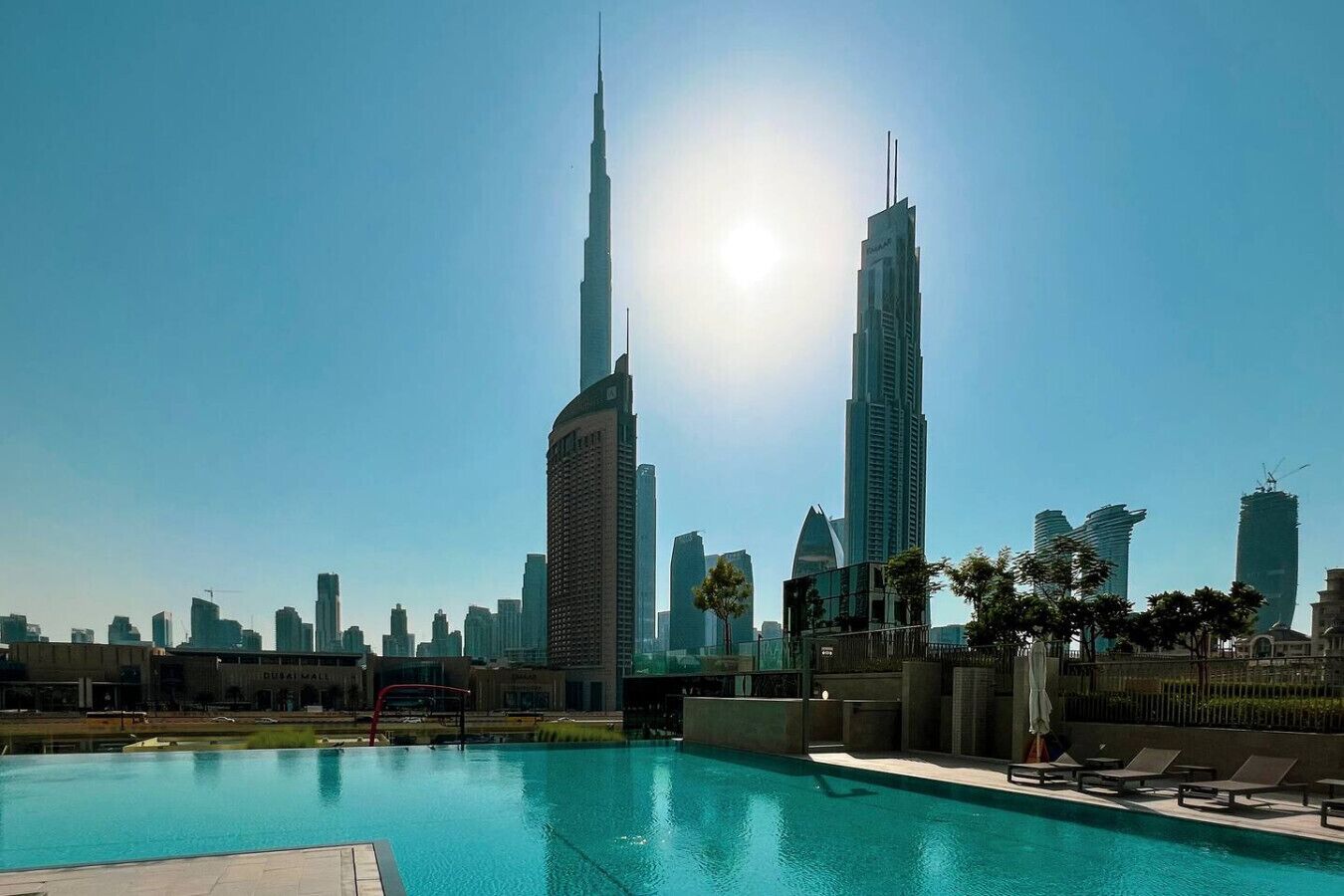 A swimming pool with a view of the Burj Khalifa and surrounding high-rise buildings.