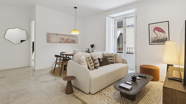 Un salon comprenant un canapé, une table basse et un coin repas avec des chaises et une table.