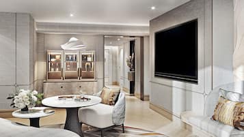 Una sala de estar moderna con una mesa redonda, un sofá, un televisor montado en la pared y un mueble decorativo.