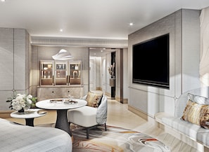 Een moderne woonkamer met een ronde salontafel, een bank, een aan de muur bevestigde televisie en een decoratiemakelaar.
