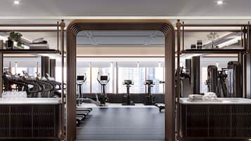 A modern gym with treadmills, elliptical machines, and weight equipment.