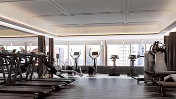 Un gimnasio moderno con cintas de correr, elípticas y equipo de pesas.