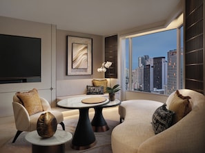 A modern living room with a city view, a flat-screen TV, and a round coffee table. - Fairmont Bangkok Sukhumvit (Bangkok)