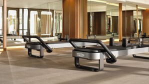Een moderne fitnessruimte met spiegelwanden, trainingsapparatuur en een overzichtelijke, ruime indeling.
