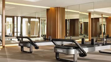 A modern gym with mirrored walls, exercise equipment, and a clean, spacious layout.