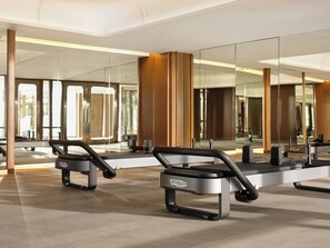 Een moderne fitnessruimte met spiegelwanden, trainingsapparatuur en een overzichtelijke, ruime indeling.