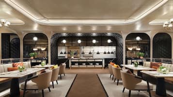A modern restaurant with a central bar, high ceiling, and symmetrical seating arrangement.