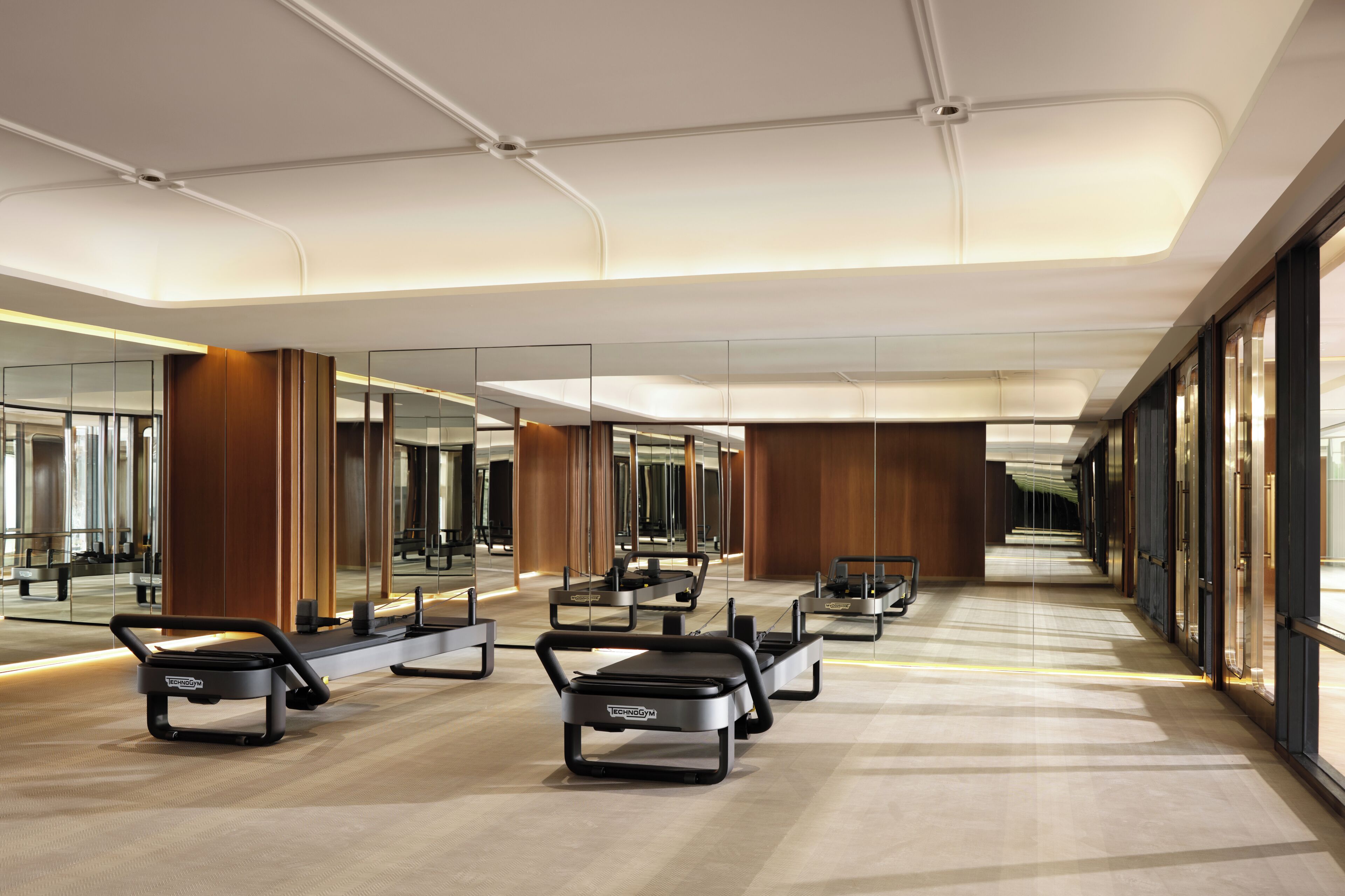 A modern hotel lobby with a central seating area, large mirrors, and a long corridor.