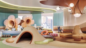 Ein modernes Wohnzimmer mit einzigartigem architektonischem Design, inklusive einer großen Holzskulptur, einem Spielbereich mit einer Tunnelrutsche und Blick auf die Stadtlandschaft durch große Fenster.